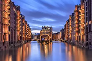 Hamburg Prints: Blue dusk and lights are reflected in Poggenmohlenbrucke with water castle between bridges