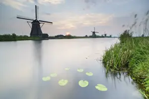 South Holland Prints: Blue sky and pink clouds on the windmills reflected in the canal at dawn, Kinderdijk