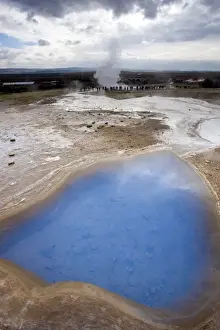 Aquamarine Prints: Blue water in geothermal pool with stream from Strokkur Geysir visible in the distance