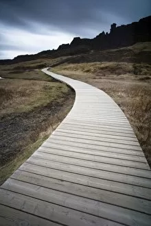 Images Dated 12th May 2010: Boardwalk meandering towards rugged cliffs and stormy sky at Thingvellir National Park near