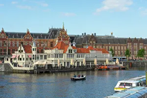 Waterfront Dining Prints: Boat on canal in front of Amsterdam Central Train Station