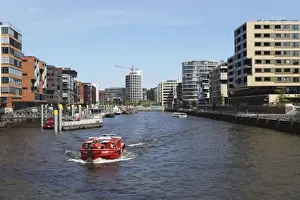 Canals Prints: A boat on a canal in the recently developed HafenCity district of Hamburg, Germany, Europe