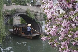 Boat passing under bridge along canal, Suzhou, Jiangsu, China, Asia