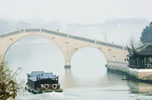 Passing Prints: A boat passing through a stone arched bridge on Waicheng River with Wumen bridge behind