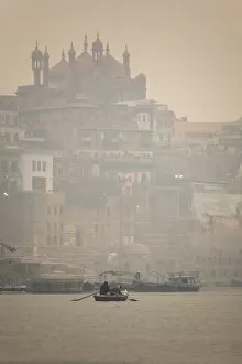 Foggy Gallery: A boat is rowed on a typically foggy morning in the Ganga (Ganges) River at Varanasi