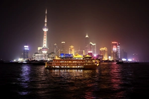 Shanghai Prints: Boat set against Shanghai illuminated skyline, Shanghai, China, Asia