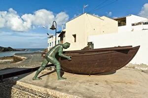 Images Dated 12th August 2010: Boat with statues of fishermen at the old harbour in this north west coast village, El Cotillo