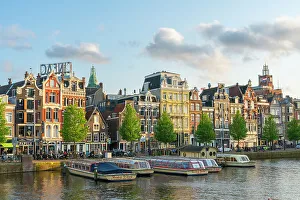 Waterfront Dining Prints: Boats on Amstel River at sunset, Amsterdam, The Netherlands, Europe