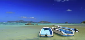 Getaway Prints: Boats anchored at Anse Source dArgent beach under sunny skies with turquoise waters and distant islands in Seychelles