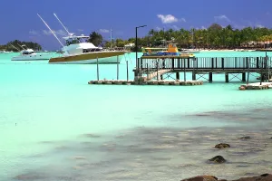 Grand Prints: Boats docked near a wooden pier in Grand Baie with clear blue waters in northern Mauritius during daylight