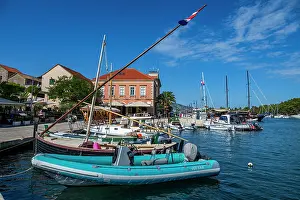 Docked Prints: Boats docked in old city of Stari Grad with clear sky and buildings in view in Hvar Croatia