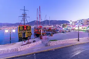 Watercraft Prints: Boats docked in Port of Limenas Chersonisou at dusk with lights reflecting on water in Crete