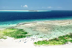 Anchor Prints: Boats on idyllic sand beach with Mnemba Island in the background