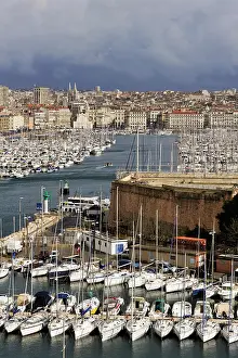 Navigation Prints: Boats line the harbor as city life thrives at the Old Port in Marseille during a cloudy day in France