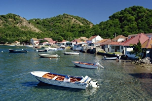 Boats moored behind houses built on the beach of a bay