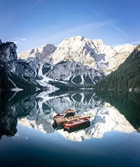 Boats moored in Lake Braies (Pragser Wildsee) with mountains reflected in water