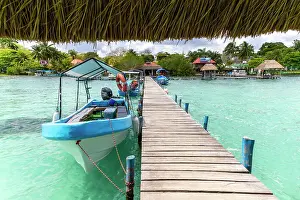 Inviting Prints: Boats moored on wooden jetty leading to land on Lake Bacalar