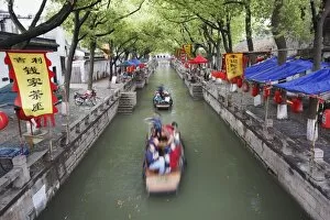 Boats taking tourists along canal, Tongli, Jiangsu, China, Asia