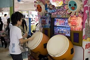 Images Dated 3rd May 2009: Boy playing a Japanese taiko drum video game at a game center, Japan, Asia