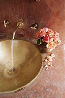 Brass Prints: Detail of brass hand beaten bathroom sink in bathroom