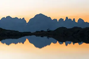 Silhouetted Prints: Brenta Dolomites mountains reflected in pristine water of Lago Nero di Cornisello