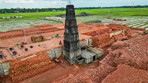Economy Prints: Brick production process at a facility surrounded by fields in Bangladesh during daylight hours