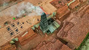 Economy Prints: Brick production process taking place at a factory with stacked bricks and a chimney in Bangladesh