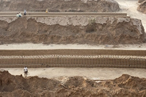 Preparation Prints: Brick workers amongst hand made bricks laid out on the ground to dry before baking