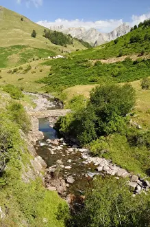 Aragon Prints: Bridge over Rio Aragon Subordan in the upper Hecho valley overlooked by karst limestone peaks and woods