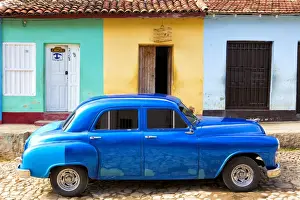 Trinidad Prints: Bright blue vintage American car parked in front of colourful painted colonial houses