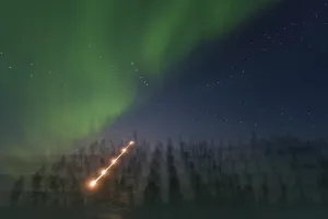 Northern Prints: Bright colors of aurora borealis dance over boreal forest at Great Slave Lake during night in Northwest Territories