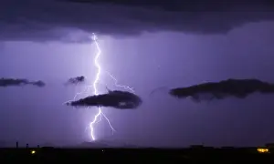Electricity Prints: A bright lightning bolt passing through a cloud and striking in the Gila Bend Mountains