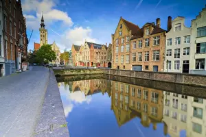 Bruges Prints: Bright sky at dawn on historic buildings and houses of city centre reflected in the canal