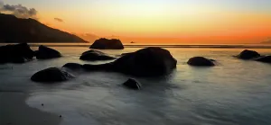 Tides Prints: Bright sunset with rocks along Beau Vallon beach in Mahe Seychelles