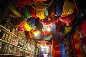 Seasoning Prints: Brightly dyed wool hanging from roof of a shop