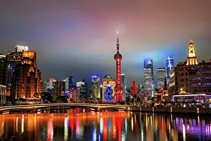 Shanghai Prints: Brightly lit skyline of Lujiazui at night covered in mist viewed from Suzhou Creek in Shanghai