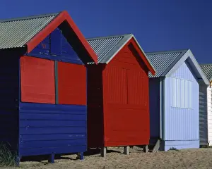 Brightly painted red and blue wooden beach bathing huts, Brighton Beach