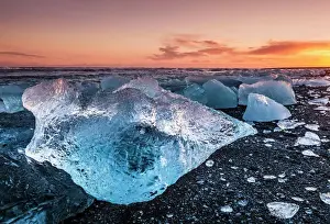 Icebergs Prints: Broken ice from washed up icebergs on Jokulsarlon black beach at sunset, Jokulsarlon