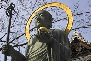 Bronze statue of the Buddha in front of a temple