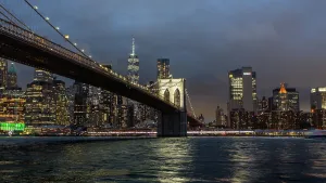 Riverside Prints: Brooklyn Bridge at dusk with city lights reflecting off the East River in New York City