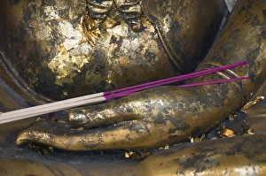 Buddha covered with gold leaf offerings and joss sticks, Bangkok, Thailand Buddha covered with gold leaf offerings and joss sticks, Bangkok, Thailand