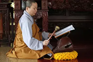 Musical Instrument Prints: Buddhist ceremony at temple, monk playing on a wooden fish (percussion instrument)