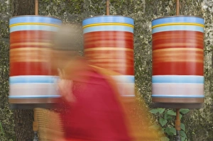 Jolly Prints: Buddhist monk passing prayer wheels