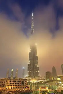 Dubai Prints: Burj Khalifa illuminates the clouds and surrounding skyline at night, Downtown