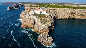 Bright Prints: Cabo de Sao Vicente lighthouse stands on a cliff by the sea in Sagres, Algarve, Portugal