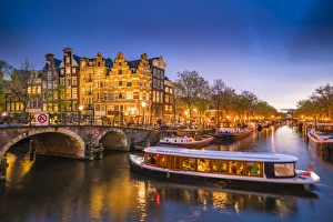Traditionally Dutch Prints: Canal scene with tour boat at dusk, Amsterdam, Netherlands, Europe