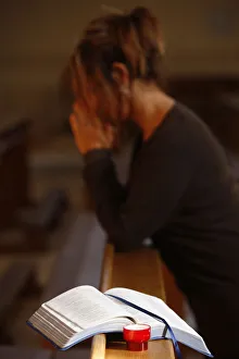Images Dated 11th November 2009: Candle and Bible, with woman praying in the background, Saint Nicolas de Veroce