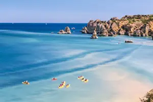 Canoe Prints: Canoes in the turquoise water of the Atlantic Ocean surrounding Praia Dona Ana beach