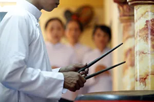 Typically Vietnamese Prints: Cao Dai worshipper playing drums, Cao Dai Temple, Phu Quoc, Vietnam, Indochina