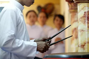 Foreground Focus Gallery: Cao Dai worshipper playing drums, Cao Dai Temple, Phu Quoc, Vietnam, Indochina